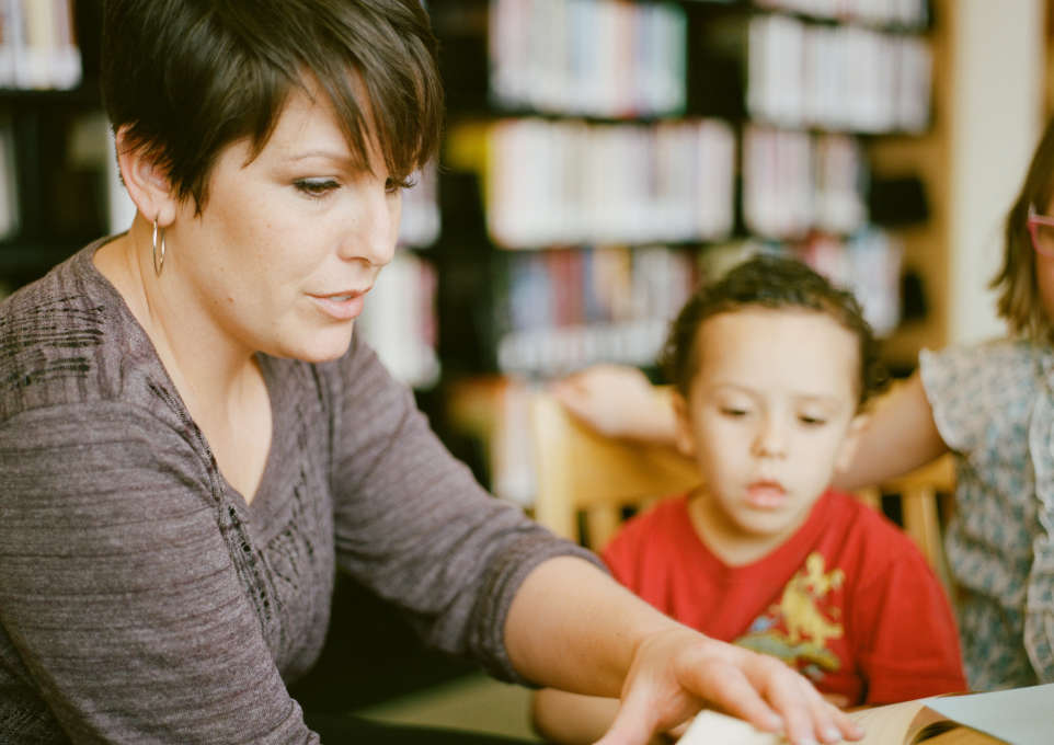 Woman reading to a child in a library
