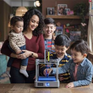 A family gathered around a 3D printer